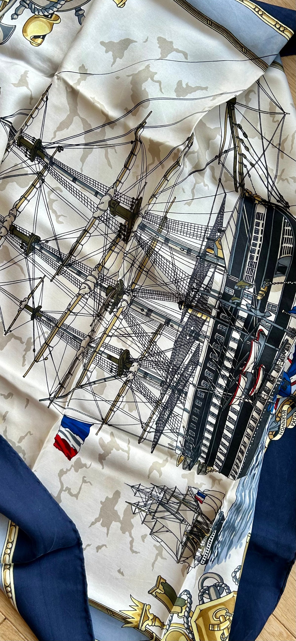 A vintage French silk scarf printed with a tall ship's rigging and tricolour flags, framed by a navy border